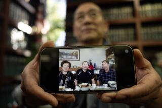 ROSEMEAD, CA - NOVEMBER 27: Yanqing Wang, the uncle of Mei Haskell, shows a picture of him, center, with his sister Yanxiang Wang, Mei's mother, and brother-in-law Li Gaoshan before their disappearance. He said he never heard any complaints about Mei Haskell's family. He had some bad feelings when he hadn't heard from his sister in almost three weeks. Photographed on Monday, Nov. 27, 2023 in Rosemead, CA. (Myung J. Chun / Los Angeles Times)