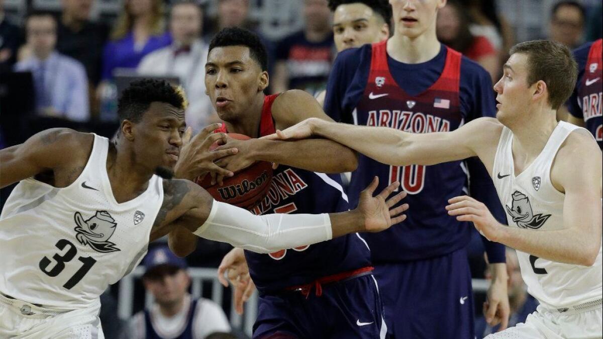 Arizona's Allonzo Trier fights through Oregon defenders Dylan Ennis, left, and Casey Benson during the first half of the Pac-12 tournament final on March 11.