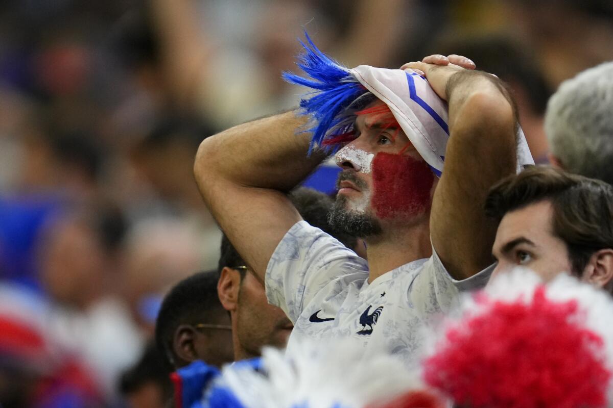A fan of France holds his head at the end of the World Cup final soccer match between Argentina and France at the Lusail Stadium in Lusail, Qatar, Sunday, Dec. 18, 2022. Argentina won in a penalty shootout. (AP Photo/Natacha Pisarenko)