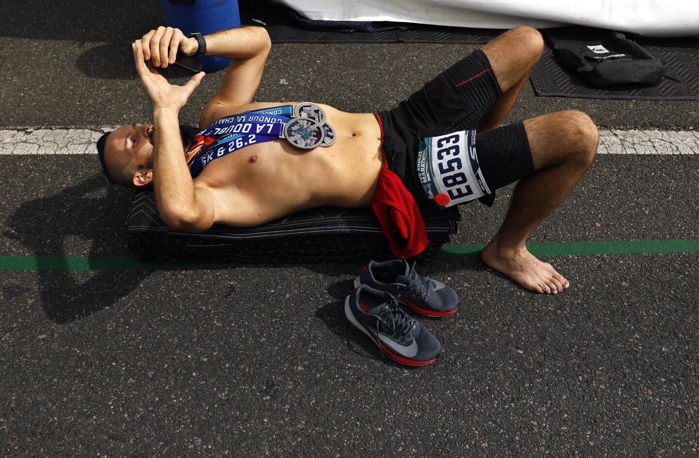 Race participant Jane Alexandru, 37, of Studio City, relaxes after finishing the L.A.Marathon on Sunday.