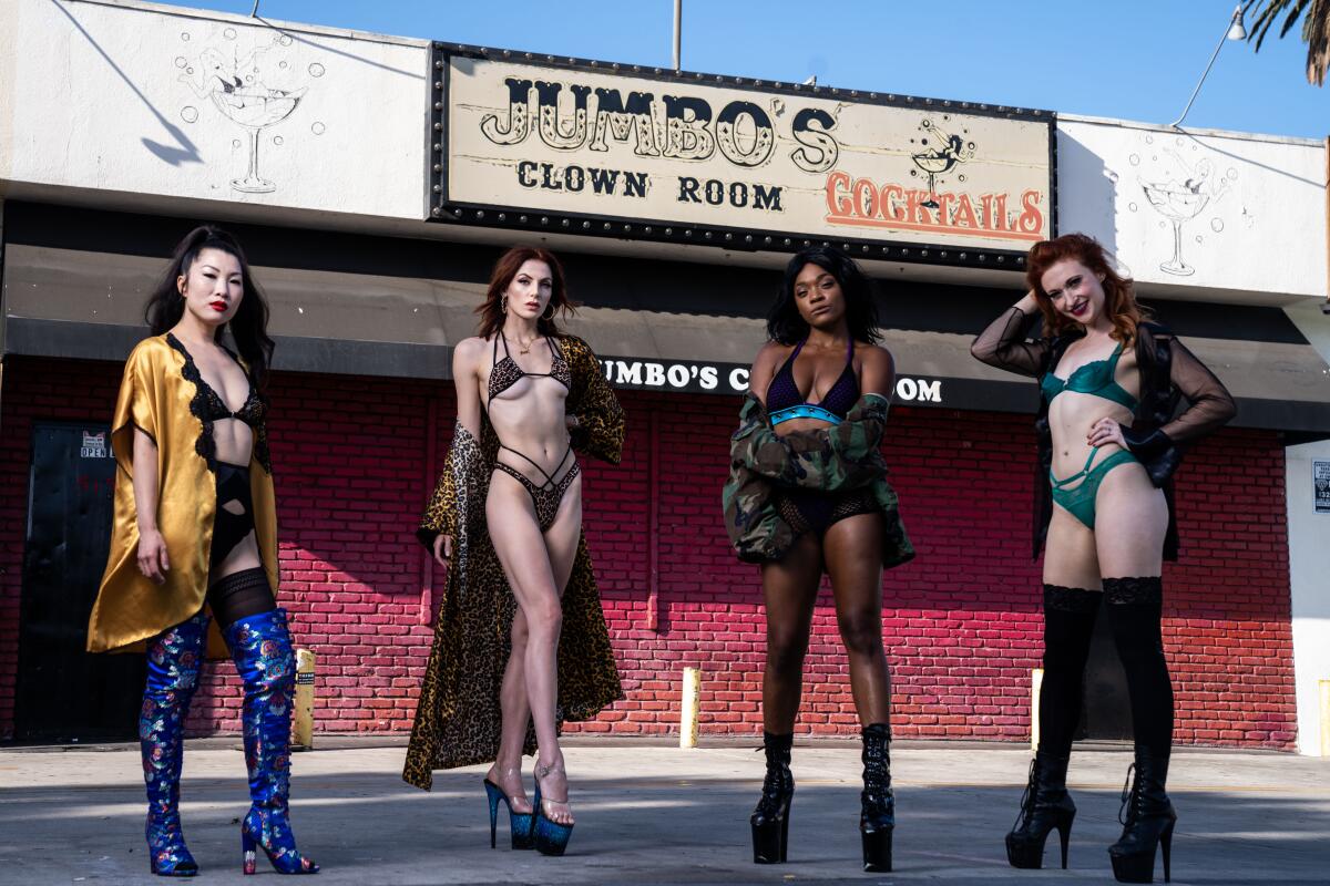 Four dancers pose in revealing outfits and high heels in front of Jumbo's Clown Room