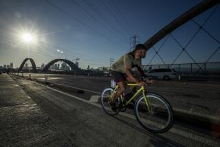 Los Angeles, CA - July 27: A cyclist rides in the bike lane crosses the new 6th Street Bridge, which has been closed intermittently since opening due to street racing and other illegal activity on Wednesday, July 27, 2022 in Los Angeles, CA. (Brian van der Brug / Los Angeles Times)