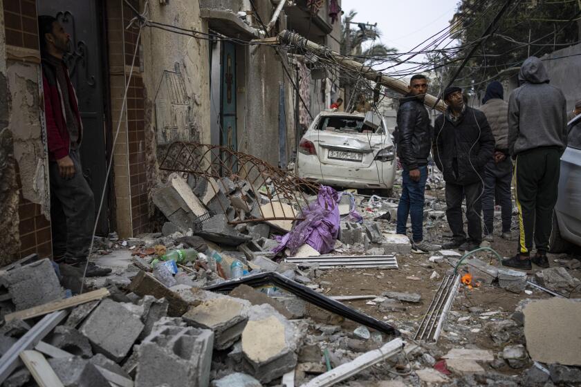 Palestinians look at the destruction after an Israeli airstrike in Rafah, Gaza SAtrip, Friday, Feb. 9, 2024. (AP Photo/Fatima Shbair)