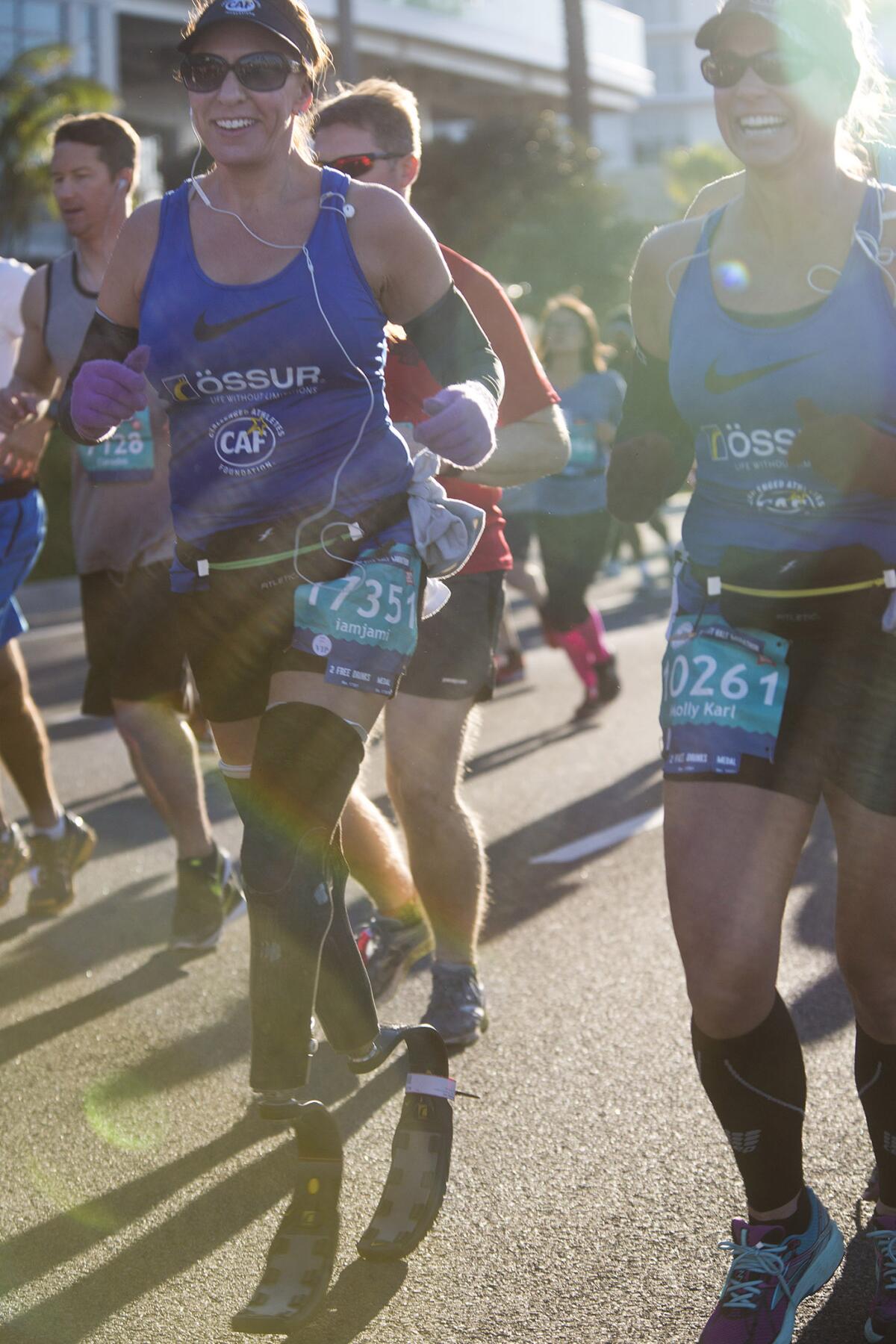 Bilateral amputee Jami Marseilles, left, completes the 2016 Surf City Half Marathon in Huntington Beach.