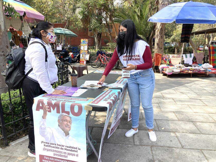 Ariadna Gómez and another volunteer collect signatures for a referendum.