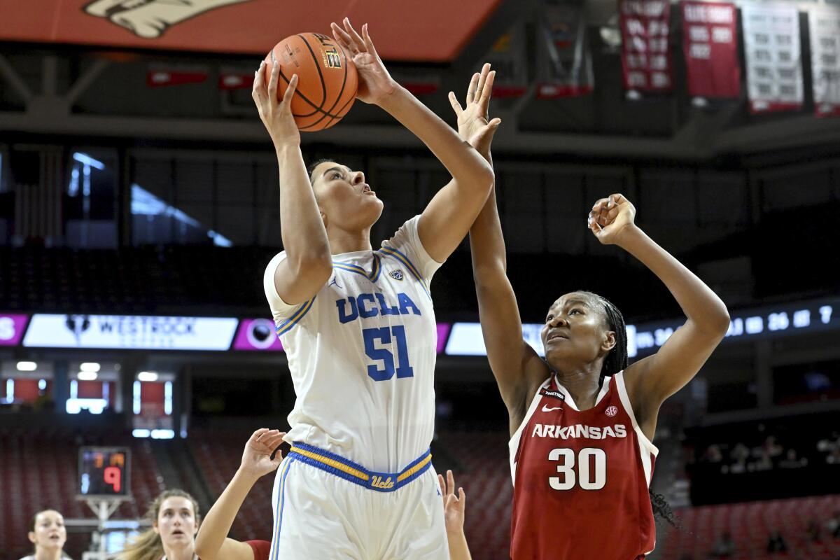 UCLA center Lauren Betts (51) takes a close-range shot over Arkansas forward Maryam Dauda (30).