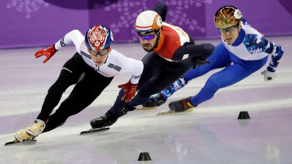 Lim Hyojun, left, holds off Sjinkie Knegt, center, and Semen Elistratov en route to winning the men's 1,500-meters short-track speedskating final on Saturday.