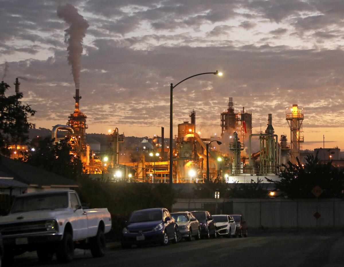 Lights illuminate a petroleum refinery at dusk.