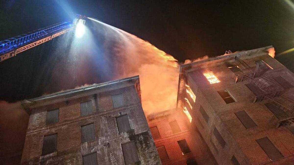 Firefighters work to douse flames from the top floor of the Hotel Marysville on Saturday