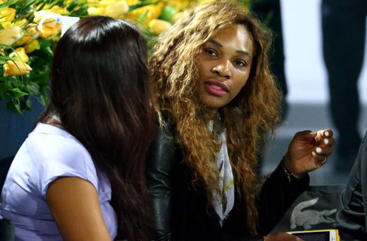 Serena Williams chats with a friend as she watches sister Venus defeat Elena Vesnina of Russia, 6-3, 6-2, in the first round of the Dubai Championships on Monday.