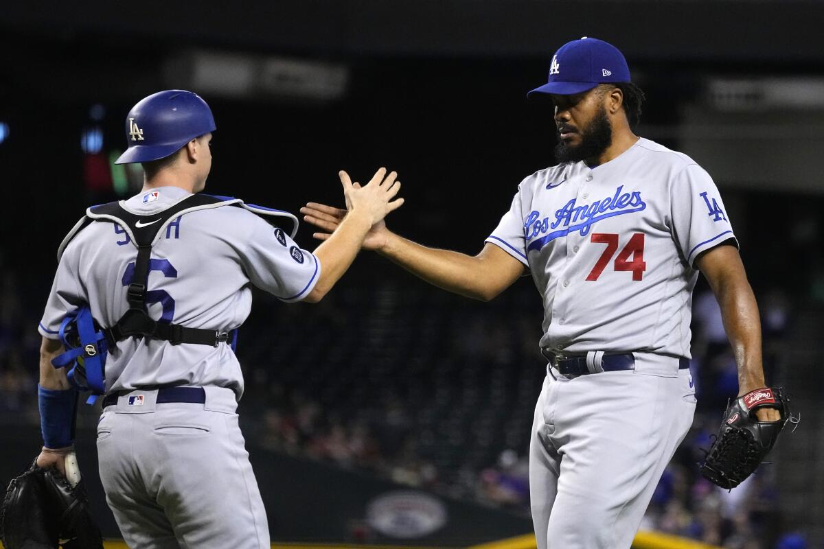 Dodgers catcher Will Smith and pitcher Kenley Jansen celebrate after a 4-2 win over the Arizona Diamondbacks on Friday.