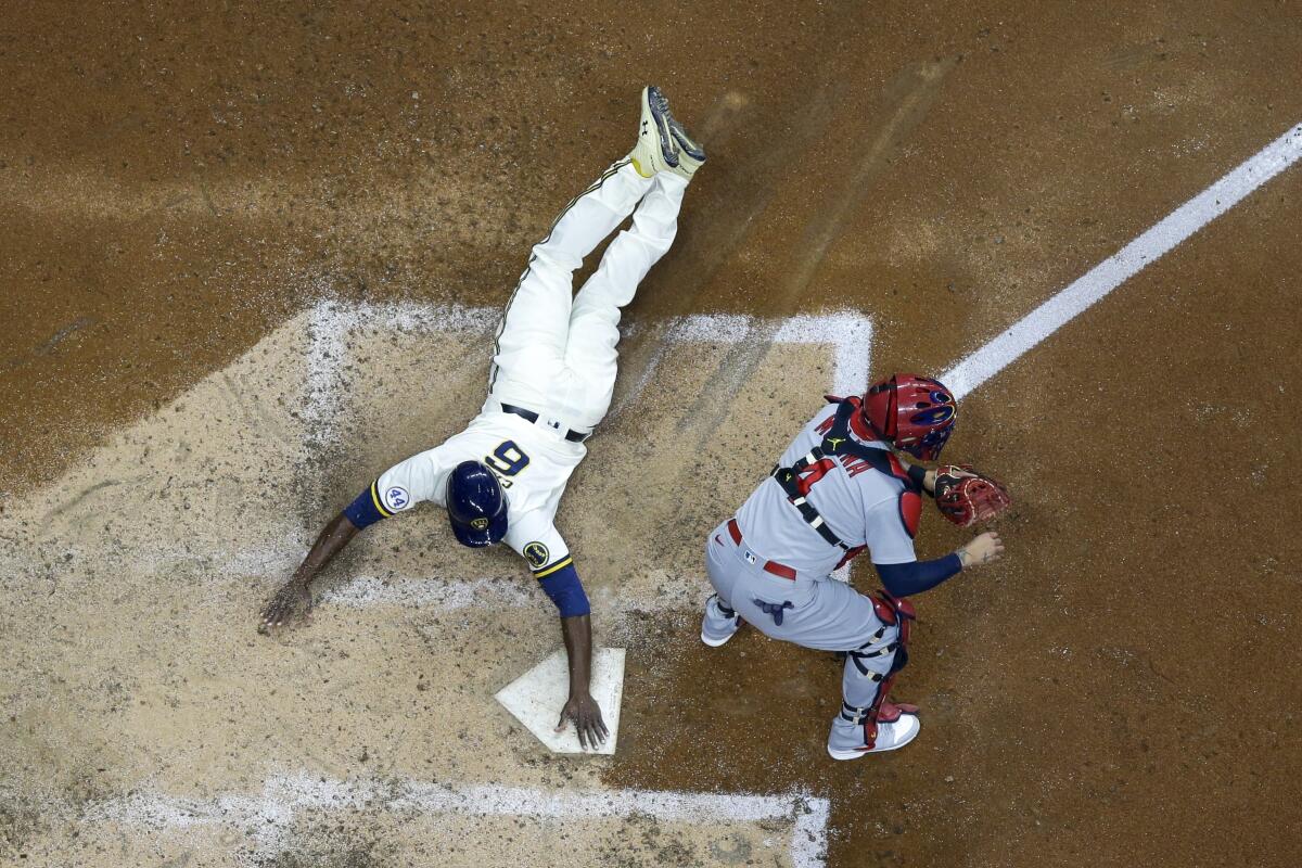 Milwaukee Brewers' Lorenzo Cain scores past St. Louis Cardinals catcher Yadier Molina during the sixth inning of a baseball game Wednesday, May 12, 2021, in Milwaukee. Cain scored from second on a ball hit by Travis Shaw. (AP Photo/Morry Gash)