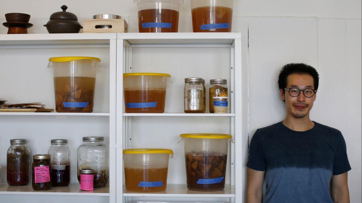 Baroo's chef Kwang Uh next to his fermentation wall.