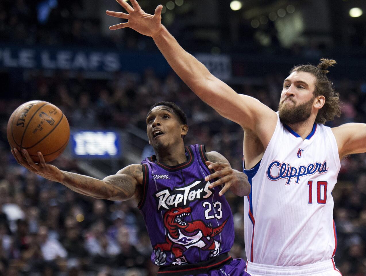 Raptors shooting guard Louis Williams uses his body to shield away Clippers center Spencer Hawes, who tries to block Williams' shot in the first half.