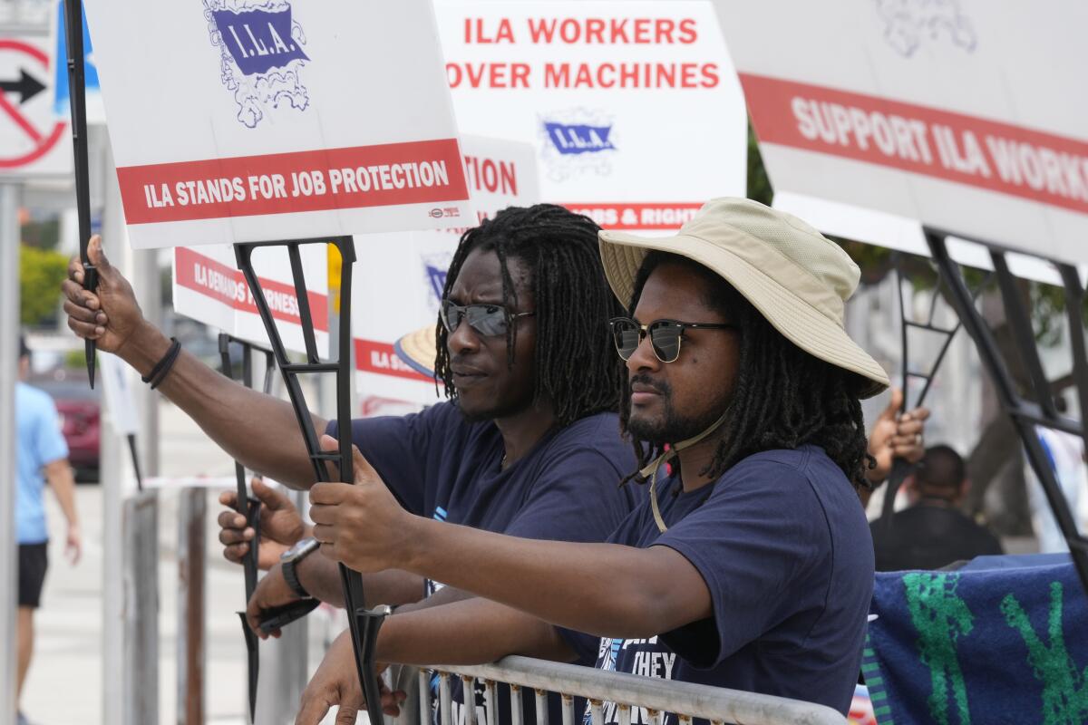 Dockworkers from Port Miami display signs at a picket line 