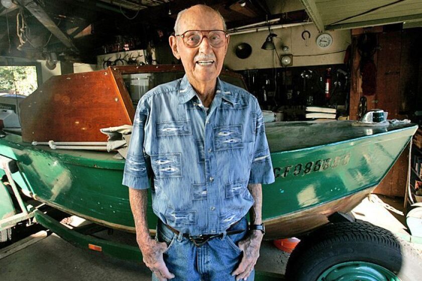 Optometrist David Jessop in the garage of his home with his fishing boat.