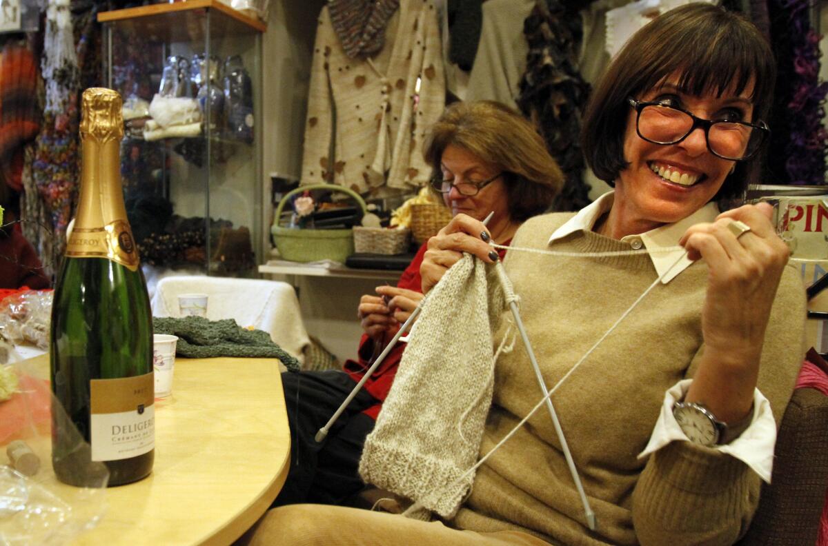 Carol Señor, left, and Penny Ellers knit and taste wine at a La Knitterie Parisienne gathering.