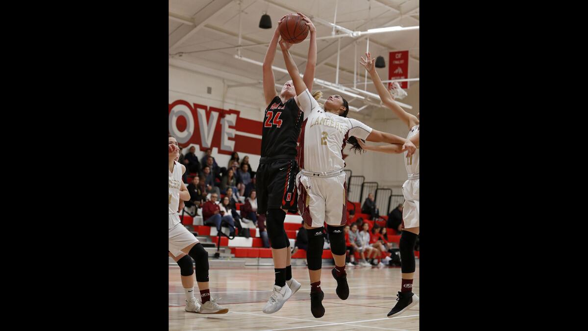 Huntington Beach High's Andie Payne (24) battles Whittier La Serna's Rosalie Avalos (2) for a rebound during the first half in the Garden Grove Classic on Dec. 27, 2018.