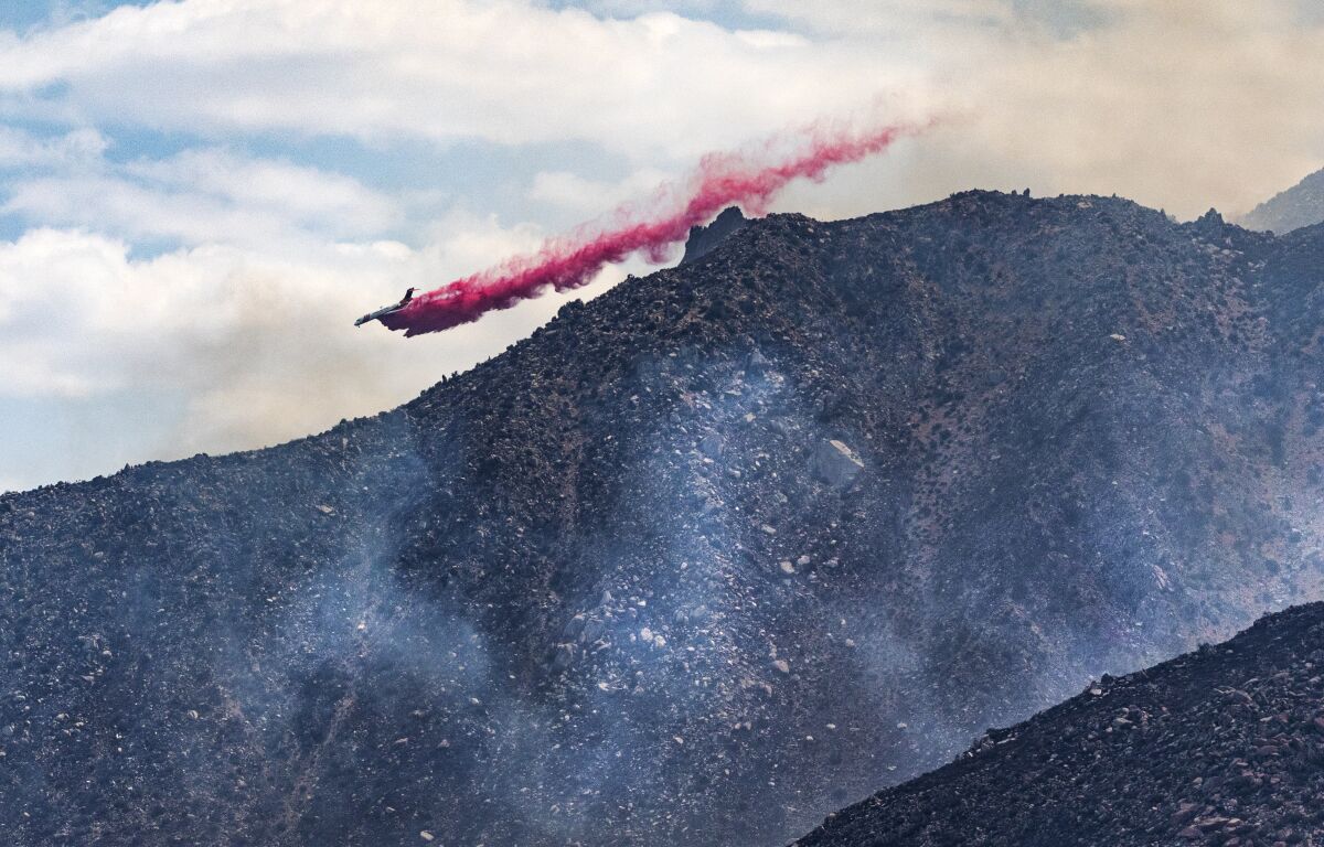 A firefighting plane drops retardant on the eastern flank of the Snow fire.