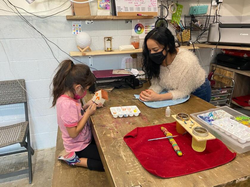 Mónica Catalán supervisa a Luna Ornelas en una clase de pintura.