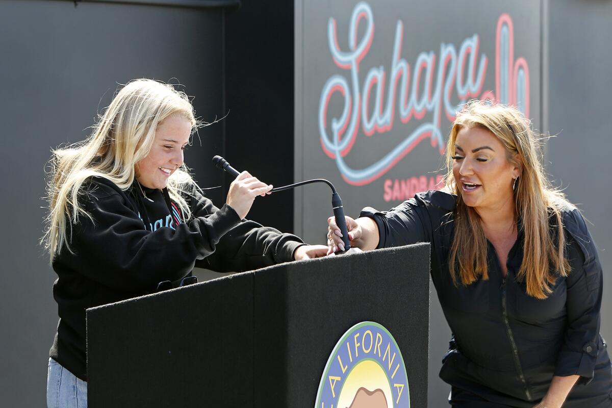 Owner Alicia Cox, right, helps adjust the microphone for her daughter, Sahara Whitney, 11, as she speaks Tuesday.
