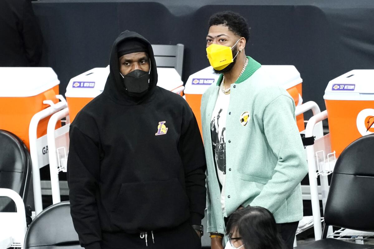 Injured forwards LeBron James and Anthony Davis watch the Lakers play the Suns in Phoenix.