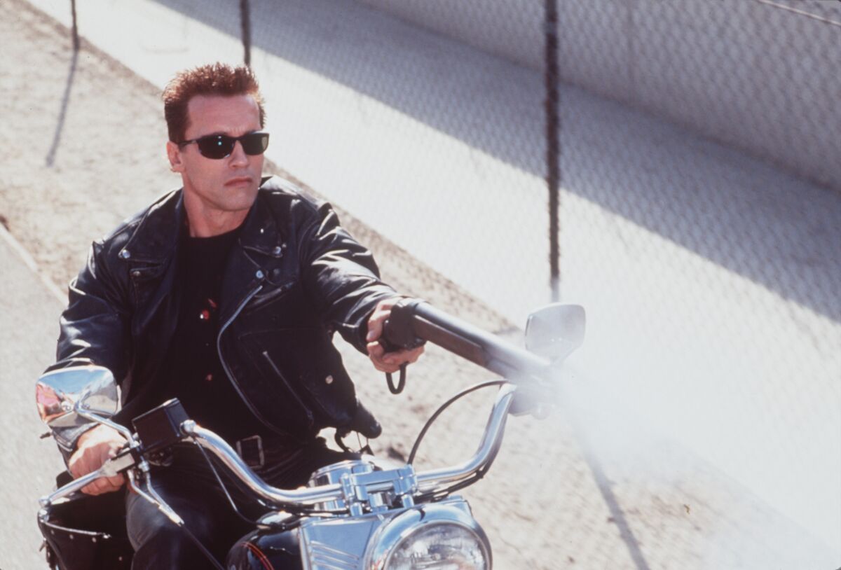 Arnold Schwarzenegger rides a motorcycle and fires a gun in "Terminator 2"