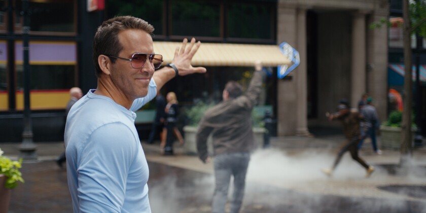 Ryan Reynolds holds up his hand in a scene from "Free Guy." 