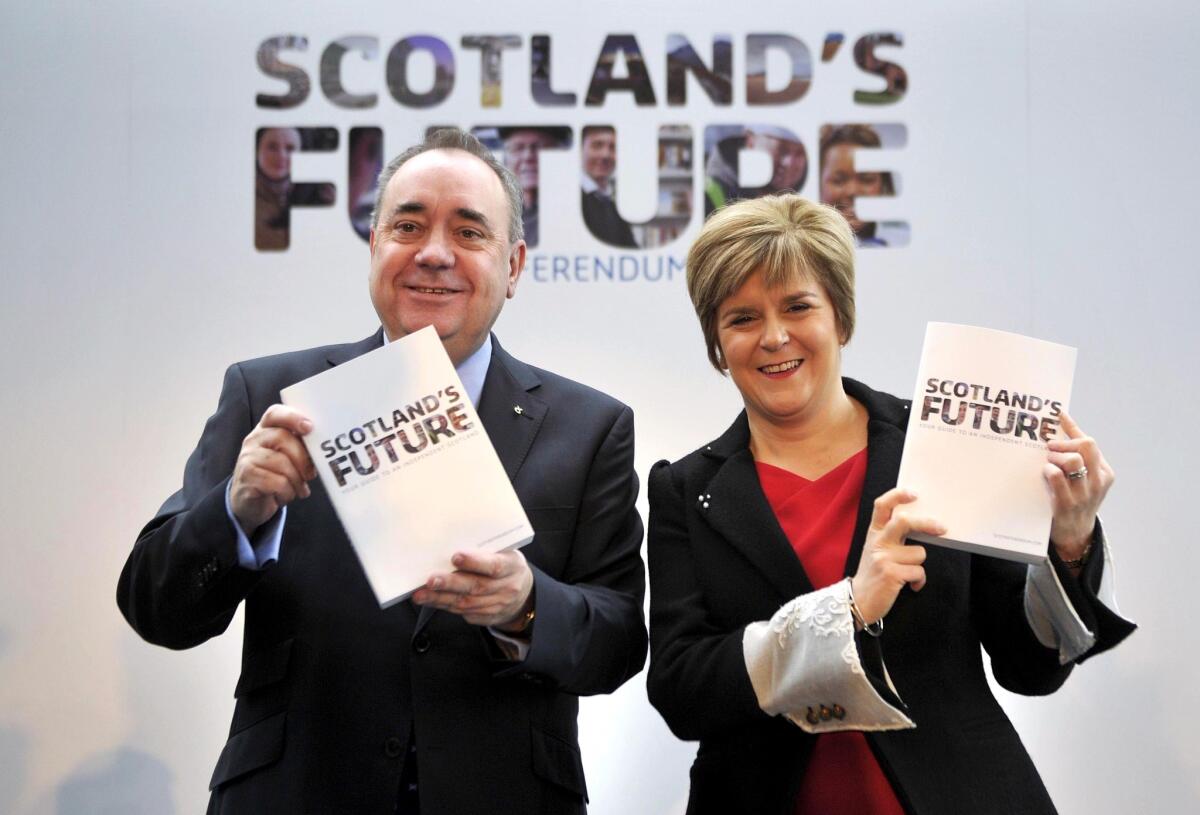 Scottish First Minister Alex Salmond and Deputy First Minister Nicola Sturgeon show off a long-awaited government report making the case for an independent Scotland.