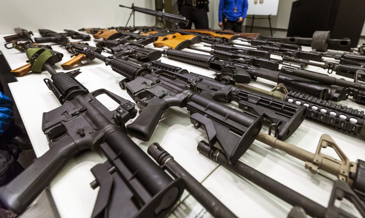 A variety of military-style semiautomatic rifles obtained during a buy back program are displayed at Los Angeles police headquarters.