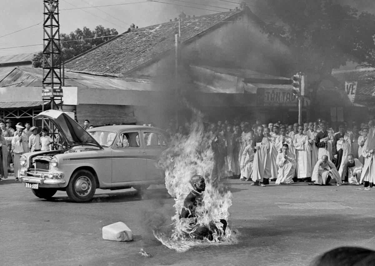 A monk sitting in an intersection, being consumed by flames