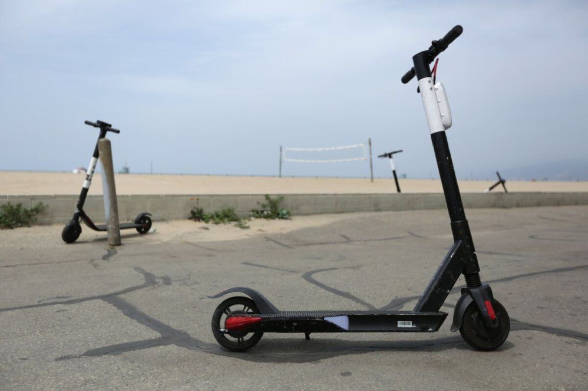 A Bird Zero (foreground) and other scooters along the beach in Santa Monica.