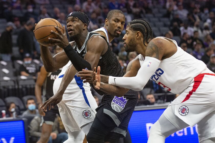 Sacramento Kings guard Terence Davis, left, drives to the basket past Los Angeles Clippers center.