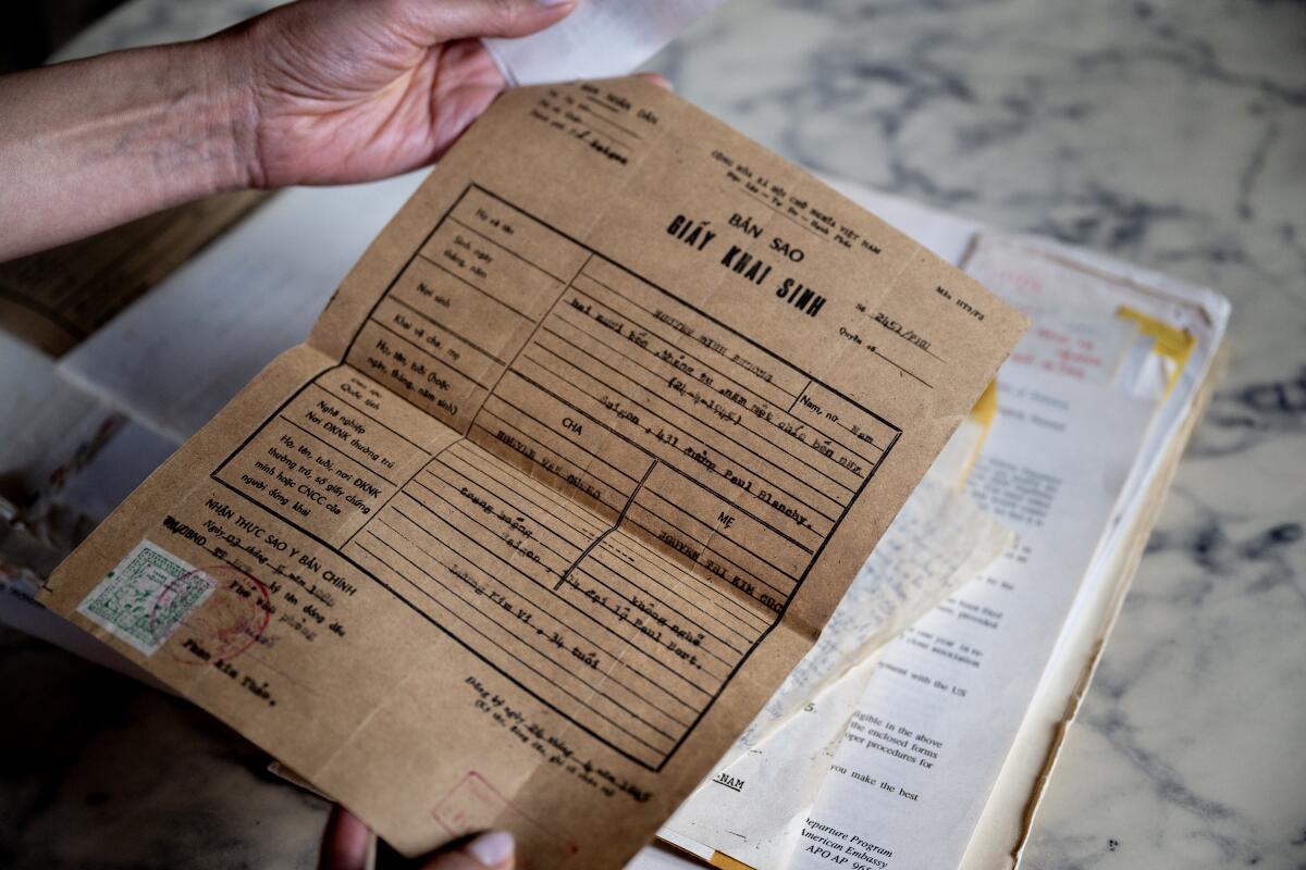 A hand holds historical family documents.