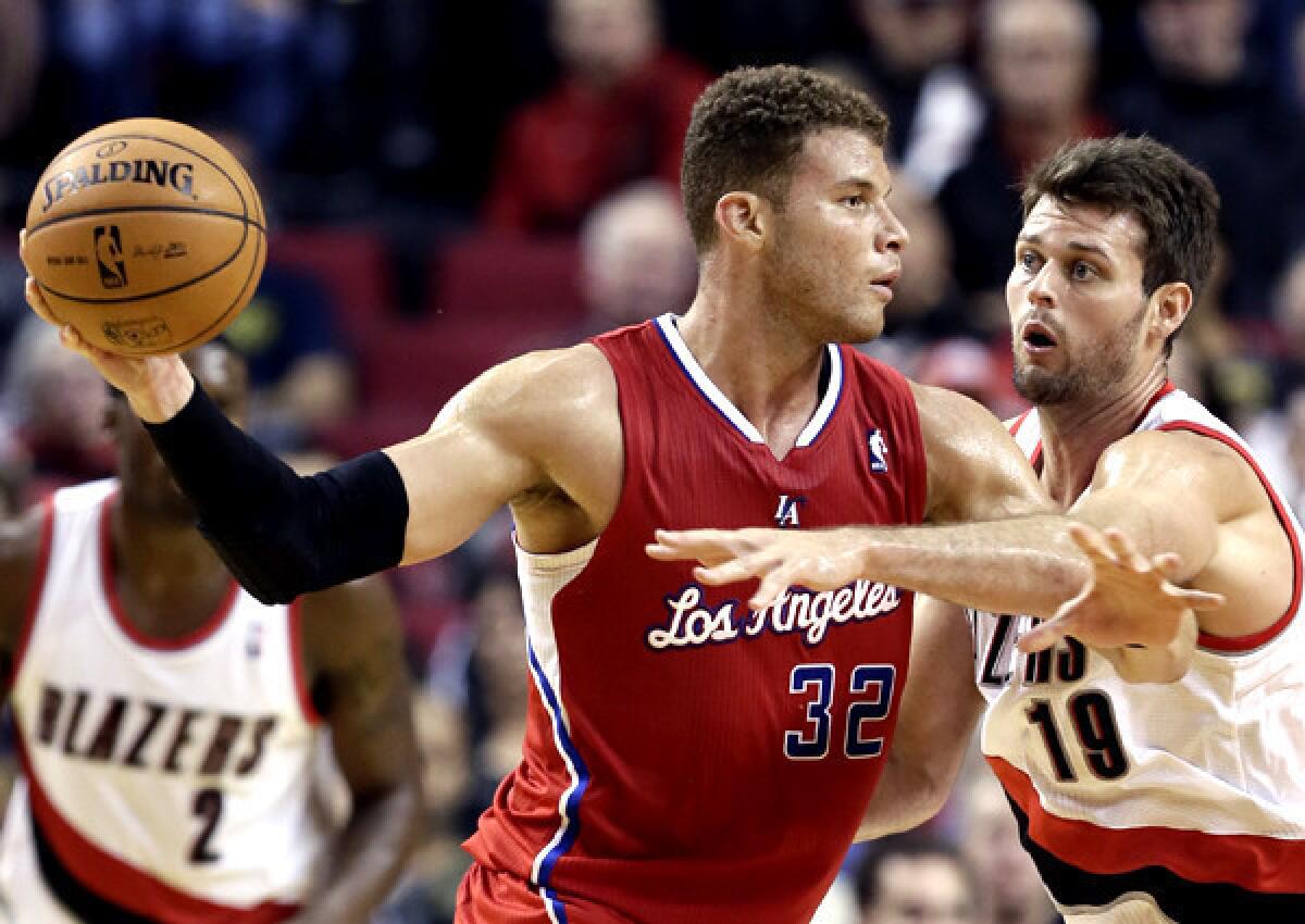 Clippers forward Blake Griffin looks to pass against the defense of Trail Blazers forward Joel Freeland during the second half of a preseason game on Monday.