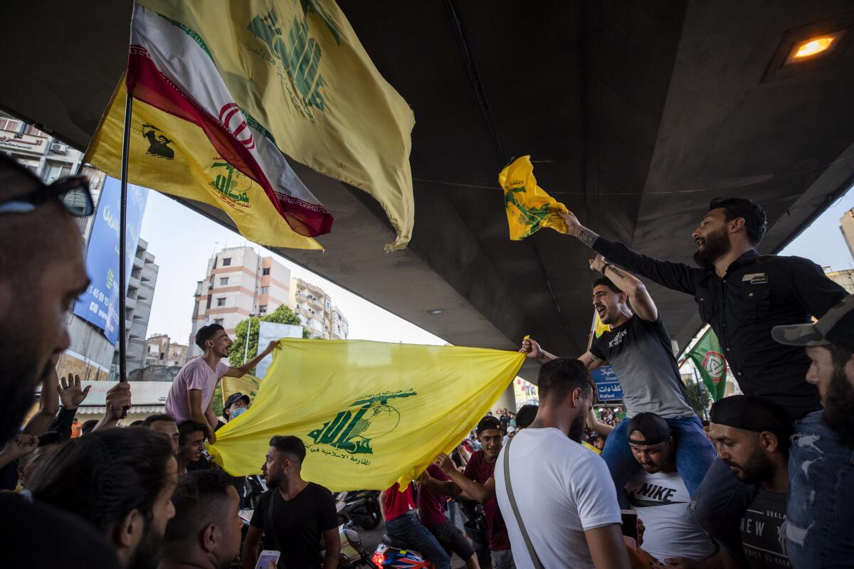Hezbollah and Amal supporters wave flags as they shout slogans against Israel and the U.S. during a protest Sunday in Beirut.