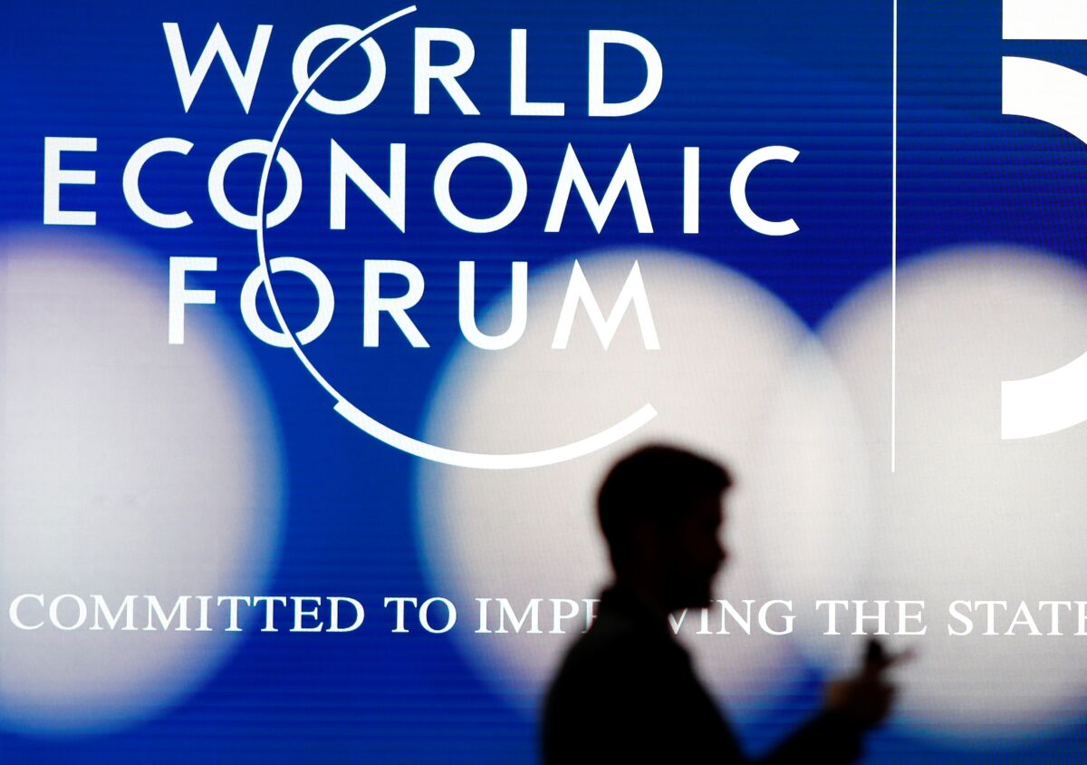 Silhouette of a man in front of the logo of the World Economic Forum
