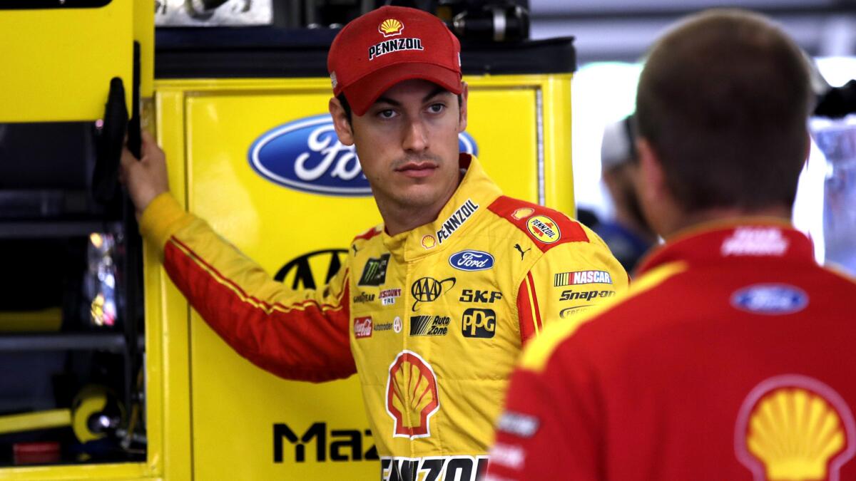 NASCAR driver Joey Logano talks with a crew member as he prepares for a practice session at New Hampshire Motor Speedway on Saturday.