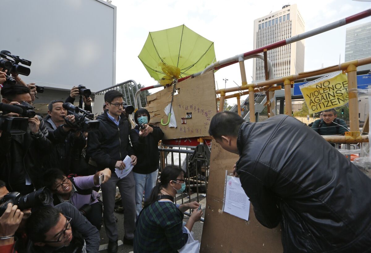 A court bailiff posts an injunction for the removal of demonstrators from occupied areas near government headquarters in Hong Kong on Dec. 9.