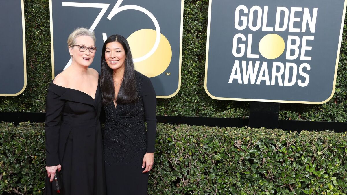 Meryl Streep, left, and activist Ai-jen Poo arrive at the 75th Golden Globe Awards on Sunday at the Beverly Hilton Hotel.