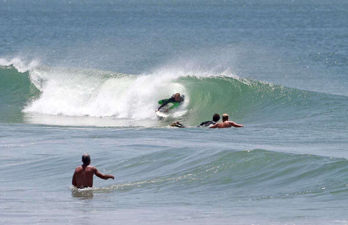 A surfer tucks into a small barrel near 44th St. in Newport Beach.