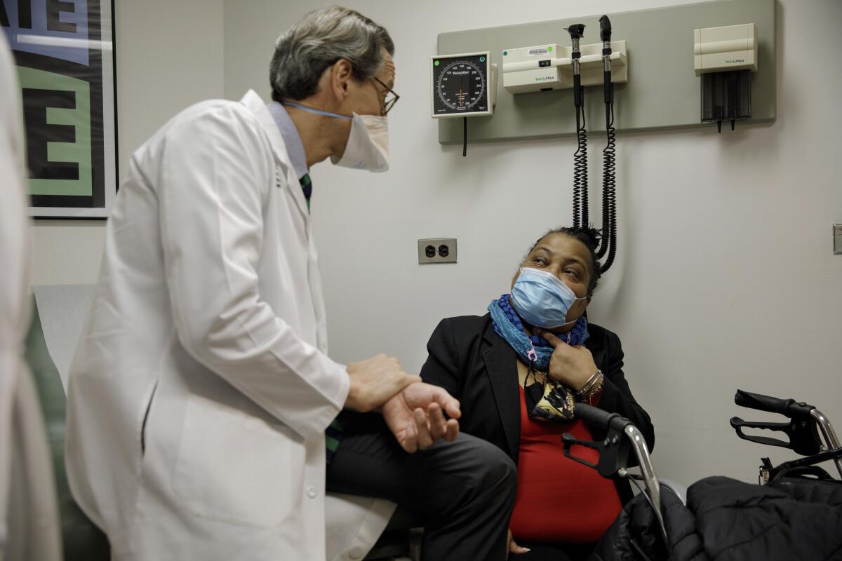 Trachea transplant recipient Sonia Sein talks with the lead surgeon of her procedure, Dr. Eric Genden, left, during a checkup visit at Mt. Sinai hospital in New York on Monday, March, 22, 2021. Sein says she had spent the last six years “trying to catch every breath at every moment" after extensive treatment for her severe asthma damaged her windpipe. But she is breathing freely again after a January windpipe transplant. (AP Photo/Marshall Ritzel)