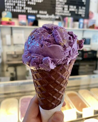 A scoop of ube malted crunch ice cream in an ube cone at Wanderlust Creamery in Pasadena.