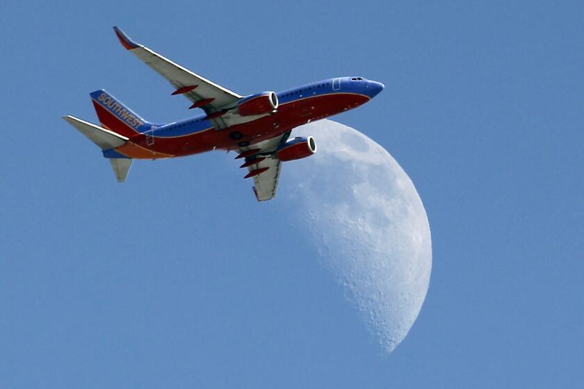 FILE - In this Sept. 1, 2014 file photo, a Southwest Air flight crosses over a crescent moon as it passes over Whittier, Calif. Southwest Air reports earnings later Thursday April 23, 2015. (AP Photo/Nick Ut, File)