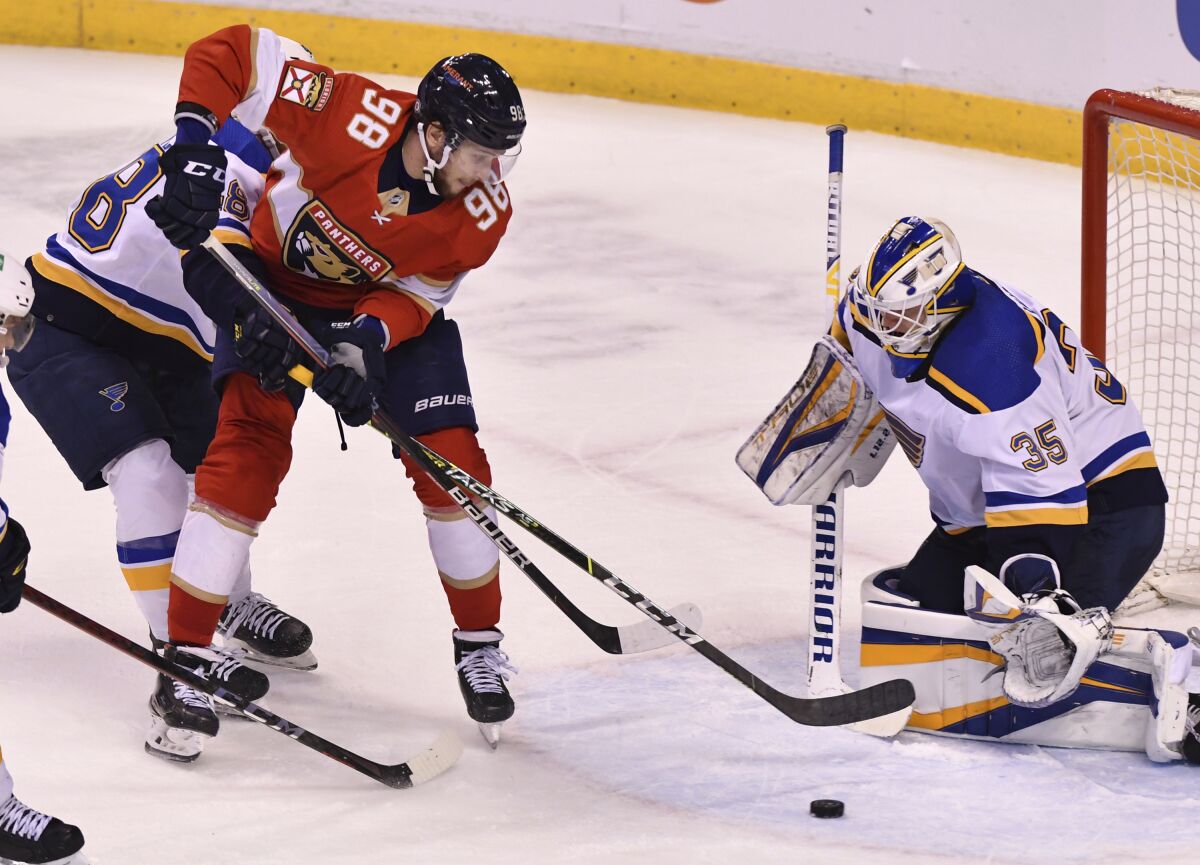 Florida Panthers right wing Maxim Mamin (98) tries to get a shot off as St. Louis Blues goaltender Ville Husso (35) clears the puck during the second period of an NHL hockey game Saturday, Dec. 4, 2021, in Sunrise, Fla. (AP Photo/Jim Rassol)