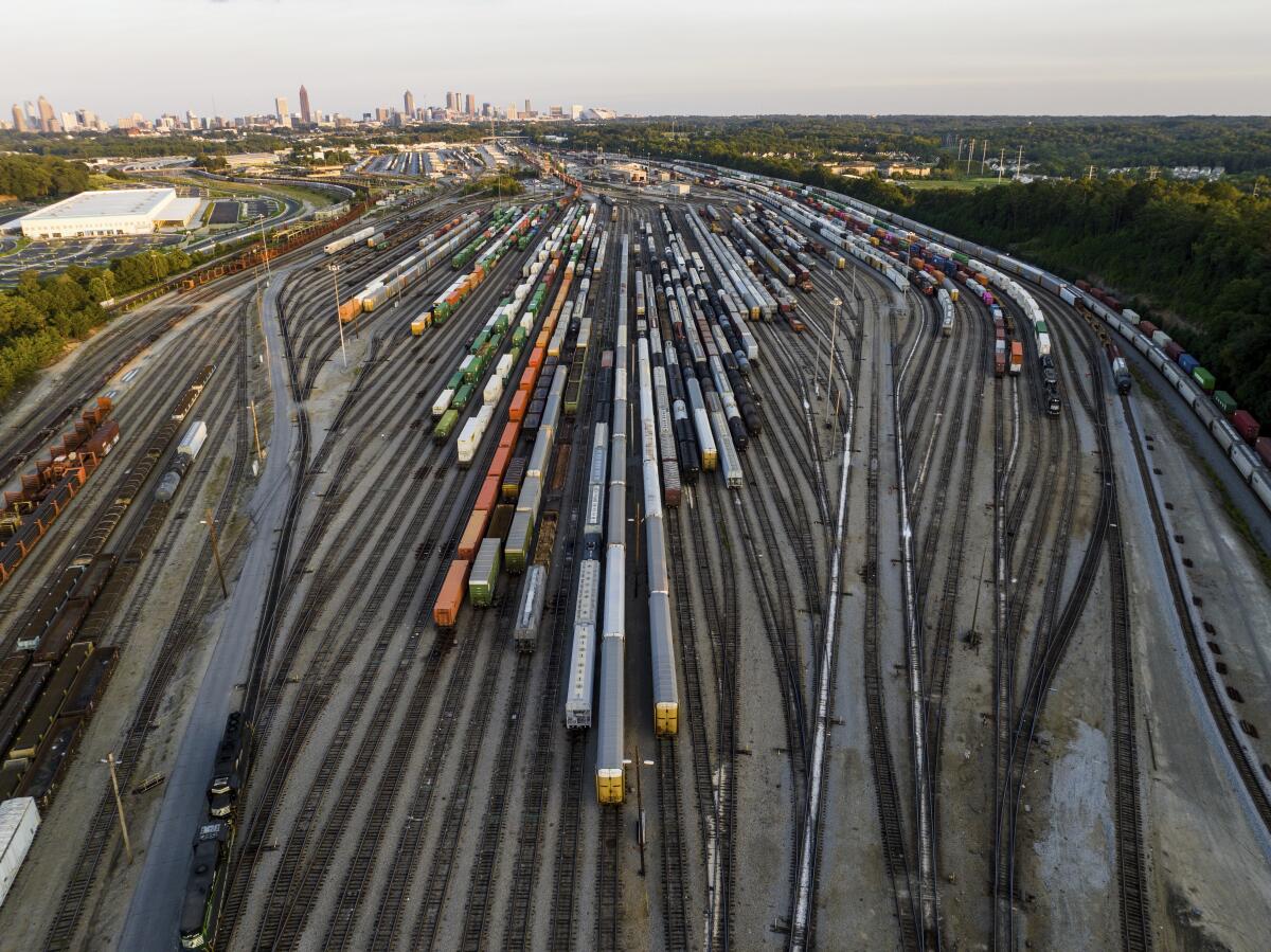 Freight train cars are lined up on tracks in a rail yard.