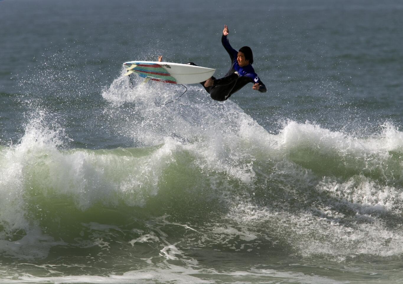 A surfer goes airborne high over a big wave at the Newport Beach jetties Wednesday.