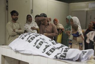 Personas lloran junto al cuerpo de un familiar que murió en una estampida, en una morgue en Karachi, Pakistán, el viernes 31 de marzo de 2023. (AP Foto/Ikram Suri)