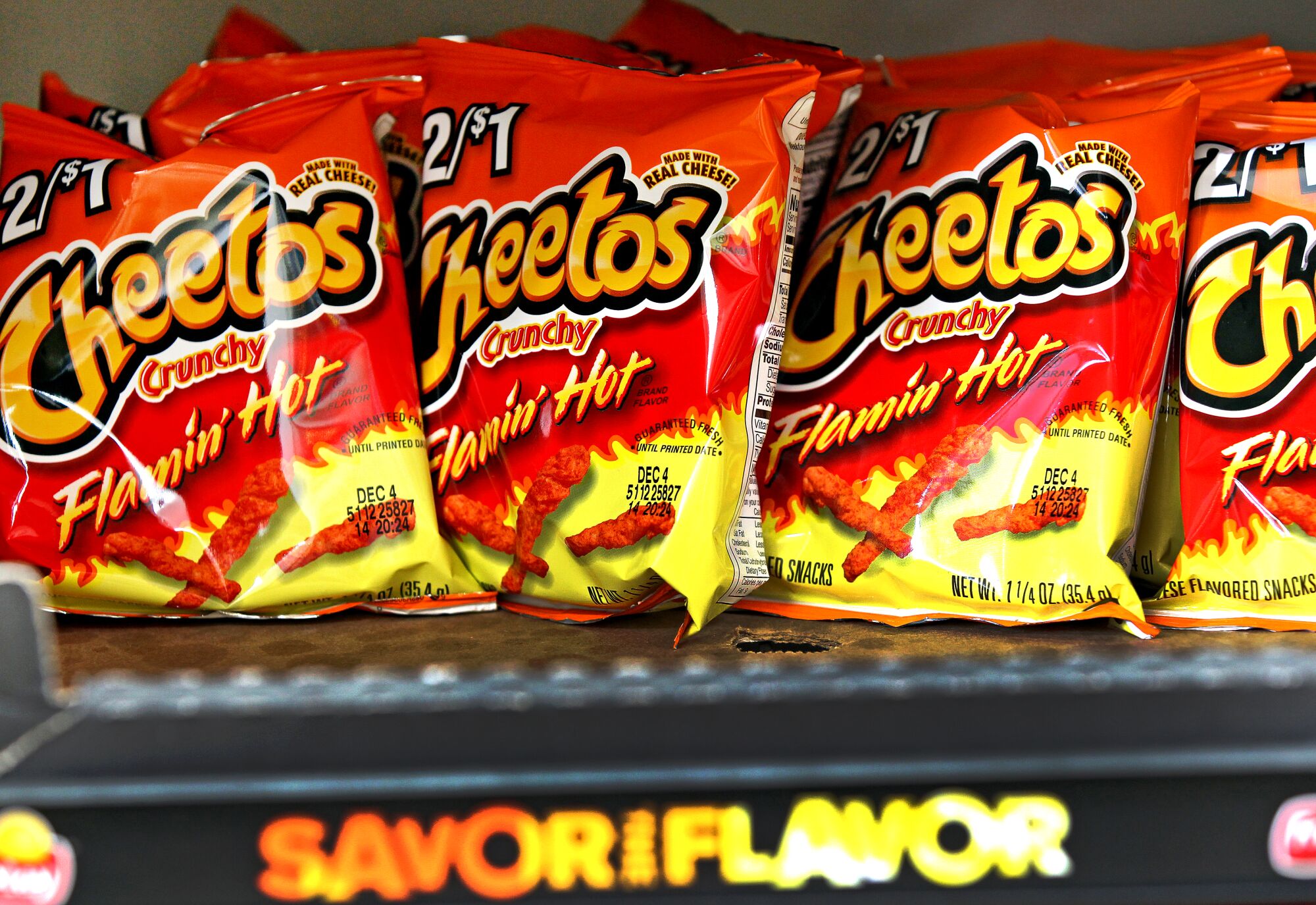 Bags of Flamin' Hot Cheetos lined up on a convenience store shelf