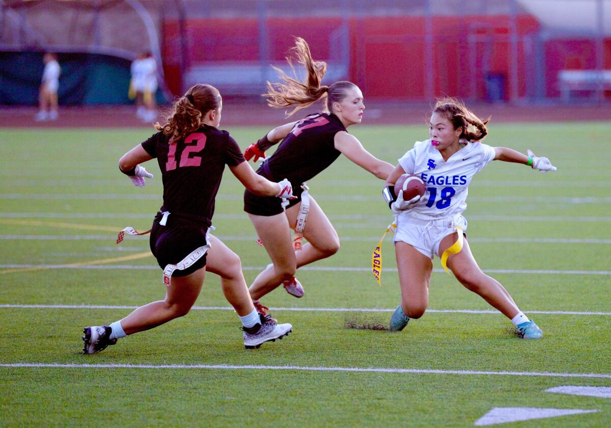 Santa Margarita's Mackenzie Young tries to evade two Orange Lutheran defenders during a Trinity League game.